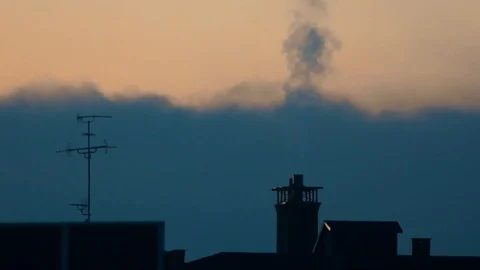 Heating system smoke stops puffing out of residential home chimney at sunset. Vídeo Stock 99254721