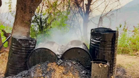 Heating up the taarcoal for raod making in hill station Stock Footage 279800099