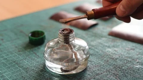 Heating the tool for working with genuine leather on the fire of  spirit lamp. Stock Footage 150477705