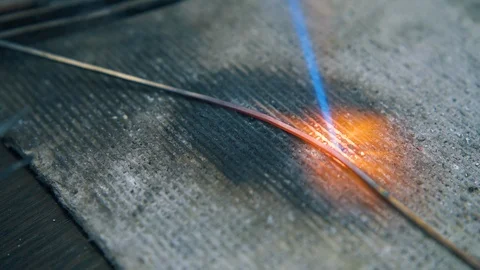 Heating of wire with gas burner on fireproof sheet closeup Video stock 120795826