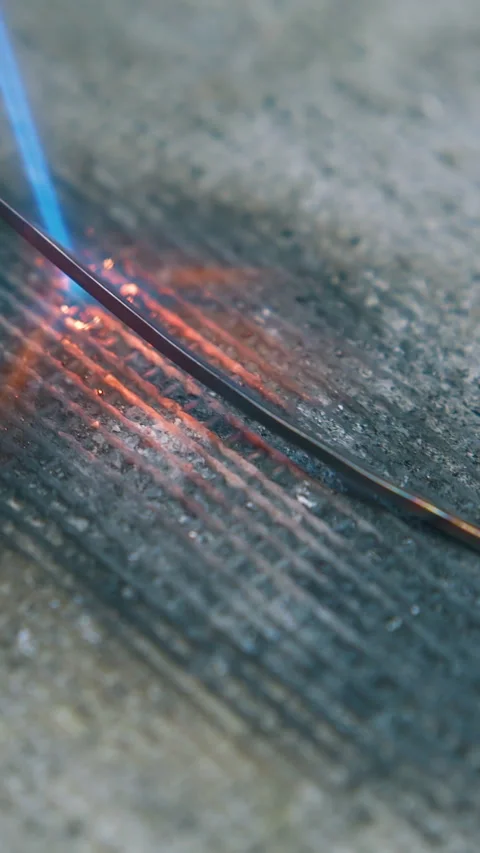 Heating of wire with gas burner on fireproof sheet closeup Video stock 317118781