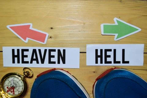 Heaven or Hell opposite direction signs with sneakers and compass on wooden Stock Photos