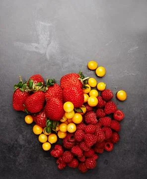 Heavenly berries. Studio shot of an assortment of berries lying on a dark Stock Photos