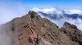 Heavenly clouds and thick fog on rocky mountain peak with pathway in La Palma Photo