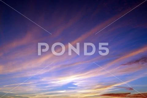 Heavenly landscape with pink clouds on purple sky during sunset. Stock Photos