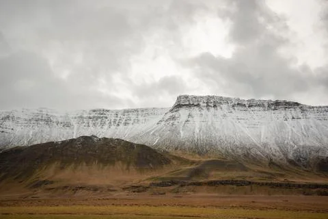 Heavenly light through the clouds over a snow capped mountain ridge leading down Stock Photos