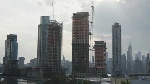 Heavenly rays cast shadows on construction skyscraper high rise buildings in Stock Footage 243811375