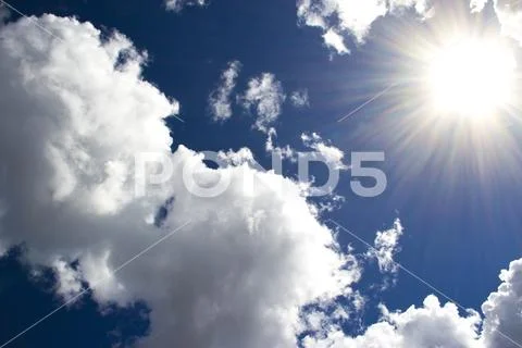 Heavenly sky between the white clouds and the radiant sun Stock Photos
