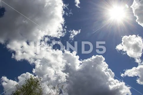 Heavenly sky between the white clouds and the radiant sun Stock Photos