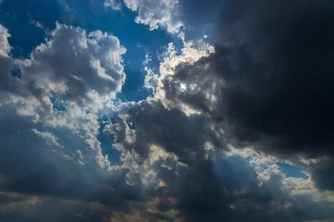 Heavenly Sun Rays Through Dark Clouds Against The Blue Sky. selective focus Stock Photos