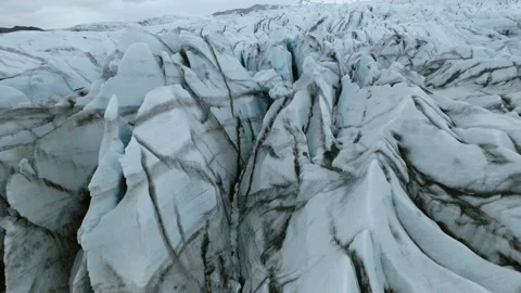 Heavily crevassed glacier ice surface with dark debris and flow structures in Stock Footage 346503845
