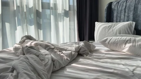 Heavily Crumpled Bed Sheets After Restless Night Sleep in Morning Light. Slider Video stock 342889921