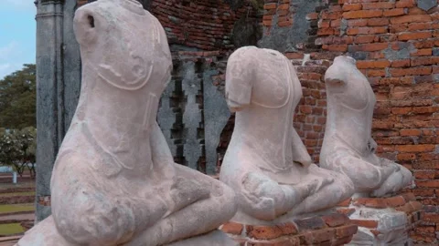 Heavily damaged statues of buddhas sit alongside each other Stock Footage 308895958
