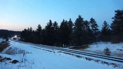 Heavily loaded coal train labors up grade during blue hour on a curve Stock Footage 105190751