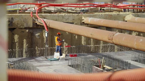 Heavily protected builder stands among concrete elements Stock Footage 346128034