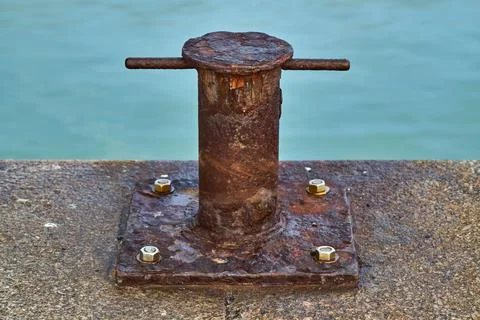 A heavily rusted samson post style single bitt mooring bollard for boats Stock Photos