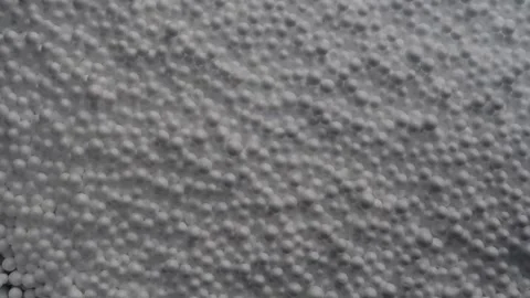 Heaving mass of small grey white polystyrene balls oozing towards viewer. Stock Footage 155919431