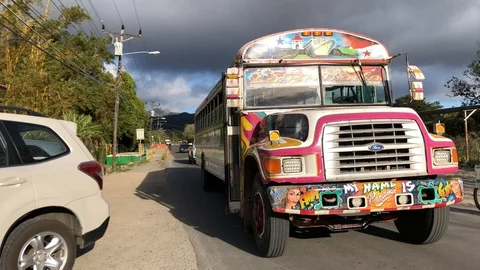 Heavy Beat up bus drives down the road in a tropical environment Stock Footage 101035204