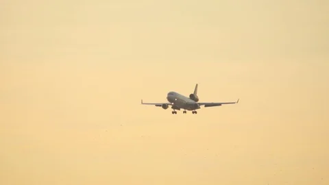 Heavy cargo airplane on final approach during golden hour at sunset. 库存影片 121357477