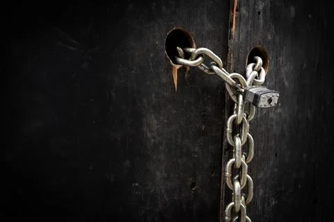 Heavy Chain and Padlock Securing Dark Wooden Doors Stock Photos