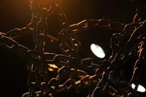 Heavy Chains in Dramatic Dark Orange Light Stock Photos