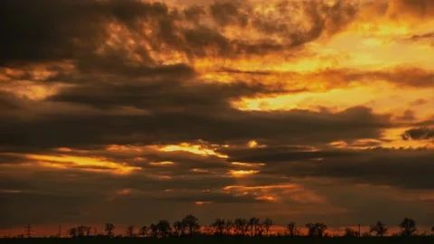 Heavy clouds float across sky at picturesque orange sunset Stock Footage 152237295