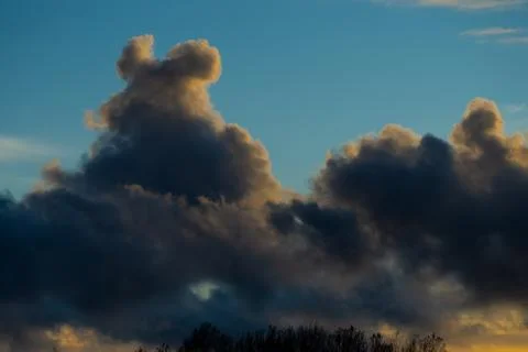 Heavy clouds forming above trees in Riga city Stock Photos