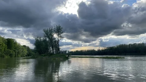 Heavy clouds over an island on the danube river Stock Footage 154339826