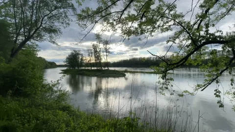 Heavy clouds over an island on the danube river Stock Footage 154339992