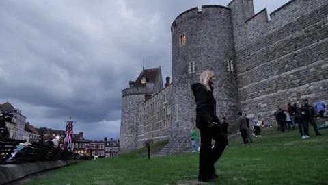 Heavy clouds over mourners laying flowers at Windsor Castle for the Queen Stock-Footage 213305370