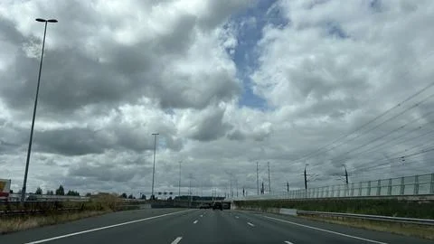 Heavy cloudy sky above multilane highway entering short tunnel in Amsterdam 写真素材