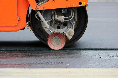 Heavy compactor tires the upper layer of asphalt in the construction of a Foto stock