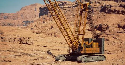 Heavy construction crane operates in arid desert landscape for mining project Illustrazione stock