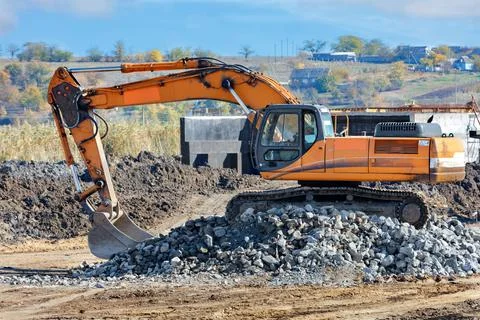 Heavy construction excavator while building a road in the countryside on an a Stock Photos