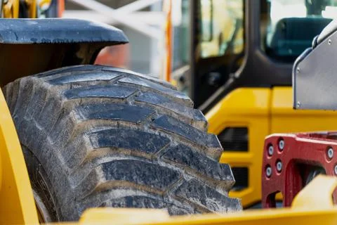 Heavy construction machine with close-up view of large rugged tire Stock Photos