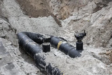 Heavy construction is ongoing at the site where large black pipes are being l Photos