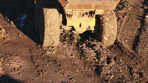 Heavy construction truck wheels driving through thick mud on site Stock Footage 340119237