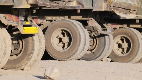 Heavy construction trucks queue up to pick up the load, close up of tires Stock Footage 285326068