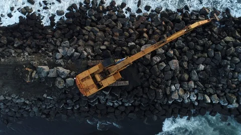 Heavy construction vehicles moving rocks on the coast in Vik, Iceland Stock Footage 122308286