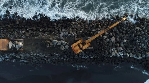 Heavy construction vehicles moving rocks on the coast in Vik, Iceland Stock Footage 122376222