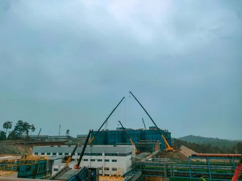 Heavy Cranes Installing Steel Structure at Industrial Construction Site Stock Photos