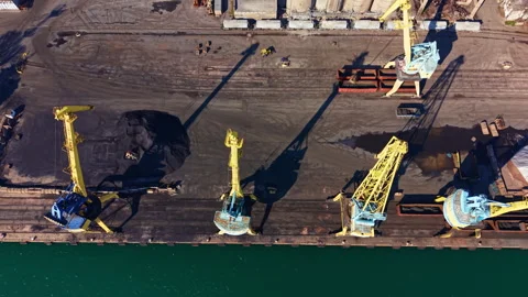 Heavy cranes unload cargo at a shipping dock along the water during daylight Stock Footage 331064043