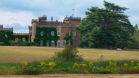 Heavy digger track passing an old english castle Stock Footage 328186540
