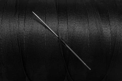 Heavy duty black thread spool with a needle horizontal full frame backdrop,.. Stock Photos