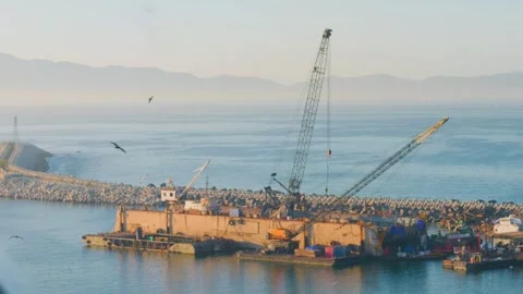 Heavy duty crane barge constructing harbor rock breakwater 库存影片 337616346