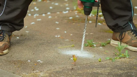 Heavy duty drill bit cutting through concrete surface during fastening hole Stock Footage 338389344