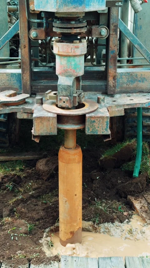 Heavy duty drilling rig operates outdoors on muddy ground, soil excavation. Stock Footage 337527574