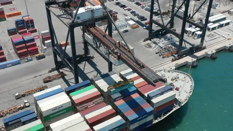 Heavy duty industrial crane unloading the docked cargo ship by lifting container Video stock 150403151
