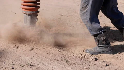 Heavy-duty soil compactor in action, compressing loose dirt for road repair Stock Footage 318710259