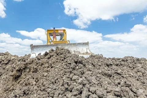 Heavy earthmover construction machine is moving earth at building site Fotos de archivo